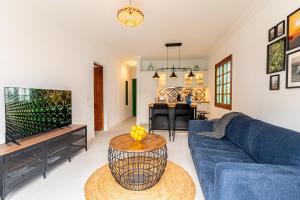 a living room with a blue couch and a tv at Casa Narnia in Puerto del Carmen