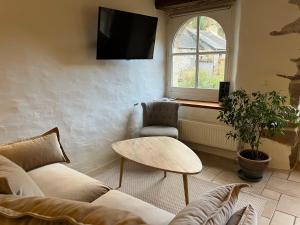 - un salon avec un canapé, une table et une fenêtre dans l'établissement La Chaumière de la Chaize, à Saint-Jouan-des-Guérets