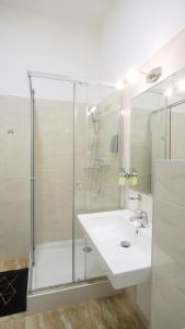 a white bathroom with a sink and a shower at Premium City Centre Bedrooms in Prešov