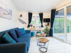 sala de estar con sofá azul y mesa en Cottage 5 personnes Bias Mimizan, en Bias