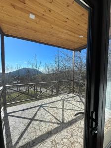 - une vue depuis la porte en verre d'une terrasse couverte avec vue dans l'établissement Pİrqulu Restaurant&Cottages, à Avaxıl