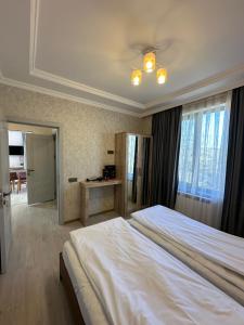 - une chambre avec un grand lit blanc et un bureau dans l'établissement Pİrqulu Restaurant&Cottages, à Avaxıl
