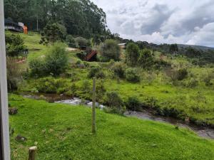a stream in a field next to a river at Chalé Eco Camping Kazeando Pelo Mundo in Urupema