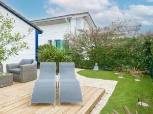 un jardín con 2 sillas en una terraza de madera en Cottage 5 personnes Bias Mimizan, en Bias