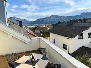 a patio with a table and chairs on a balcony at 17er Apartment mit Sauna und privater Garage in Mondsee