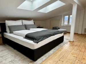 Schlafzimmer mit einem großen Bett und einem Dachfenster in der Unterkunft 17er Apartment mit Sauna und privater Garage in Mondsee