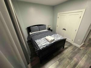 a bedroom with a bed with a black and white comforter at The Stylish Suite - 1BR with Free Parking in Paterson