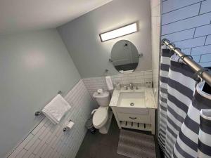 a bathroom with a sink and a toilet and a mirror at The Stylish Suite - 1BR with Free Parking in Paterson