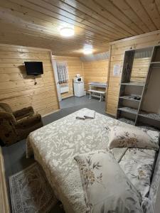een slaapkamer met een bed en een tv in een kamer bij Sadyba Dana in Tatariv