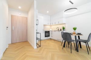 een keuken en eetkamer met een tafel en stoelen bij Blue Apartment Ceglana - FREE PARKING - Self check-in in Katowice