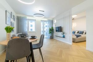 een eetkamer en woonkamer met een tafel en stoelen bij Blue Apartment Ceglana - FREE PARKING - Self check-in in Katowice