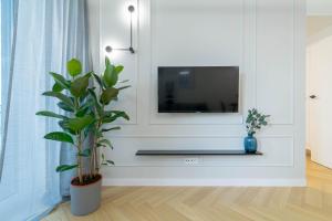een woonkamer met een tv en een plant bij Blue Apartment Ceglana - FREE PARKING - Self check-in in Katowice