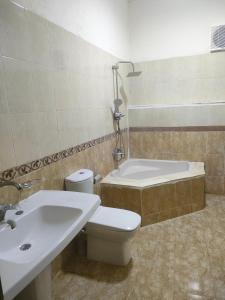 y baño con aseo, bañera y lavamanos. en New Tut pyramids hotel, en El Cairo