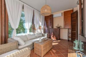 a living room with a white couch and a table at Casa Eucalipto - Marina di campo, Elba in Marina di Campo