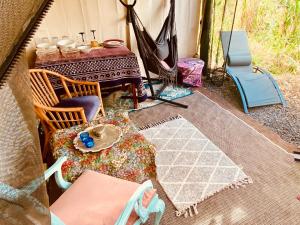patio ze stołem i krzesłami oraz namiotem w obiekcie Artsy Cabin on Organic Farm w mieście Naalehu