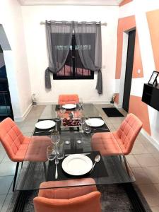 a dining room with a table and orange chairs at Résidence meublée in Ouagadougou