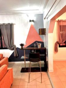 een woonkamer met een tafel en een stoel bij Résidence meublée in Ouagadougou