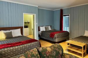 une chambre d'hôtel avec deux lits et un canapé dans l'établissement Aux Portes du Soleil, à Baie-Saint-Paul