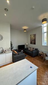 a living room with two couches and a kitchen at Stunning Salford Quays Apartment in Manchester