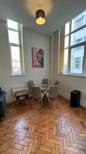 a room with a table and chairs and windows at Stunning Salford Quays Apartment in Manchester