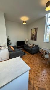 a living room with two couches and a table at Stunning Salford Quays Apartment in Manchester
