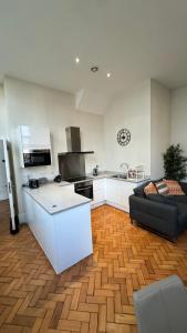 a living room with a kitchen and a couch at Stunning Salford Quays Apartment in Manchester