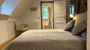 a bedroom with a large bed in a attic at Dachgeschosswohnung Warft Simmerdeis in Reetdachhaus mit parkähnlichem Garten in Oldenswort