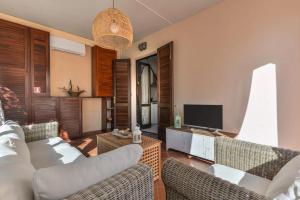a living room with a couch and a tv at Casa Eucalipto - Marina di campo, Elba in Marina di Campo