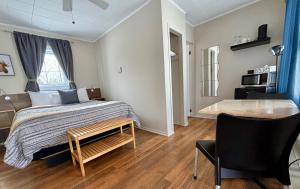 1 dormitorio con 1 cama, 1 mesa y 1 silla en Aux Portes du Soleil, en Baie-Saint-Paul