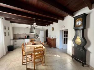 een keuken met een tafel en een klok in een kamer bij MAS DE LA BOURIDE in Bellegarde