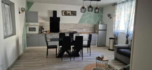 a kitchen and dining room with a table and chairs at Le Cocon de Mila in Uzer