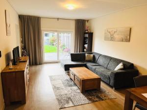 een woonkamer met een bank en een tafel bij Rustig gelegen recreatiewoning in Zeeland in Bruinisse