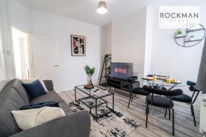 a living room with a couch and a table at Spacious 7 Bed House with Garden by Rockman Stays in Southend-on-Sea
