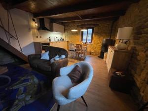 La Petite Maison de Torgny في Torgny: غرفة معيشة مع كرسيين وأريكة