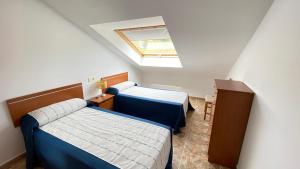Cette chambre comprend deux lits et une lucarne. dans l'établissement Ático - Avenida Galicia 60, à Finisterre