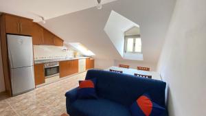 a living room with a blue couch in a kitchen at Ático - Avenida Galicia 60 in Finisterre