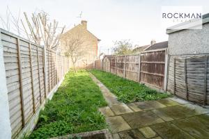a fence in a yard next to a house at Spacious 7 Bed House with Garden by Rockman Stays in Southend-on-Sea