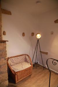 um quarto com uma cesta e uma luz sobre um tripé em La Petite Maison de Torgny em Torgny