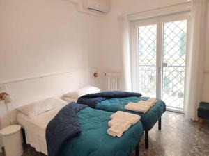 two twin beds in a room with a window at Sunnyhome- Ostia Lido vista mare 2 bagni in Lido di Ostia