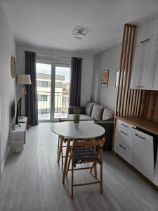 een woonkamer met een tafel en een bank bij Apartament - Osiedle Przylesie in Namysłów