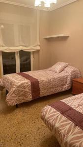 a bedroom with two beds and a window at Piso en plena Herradura. in Haro