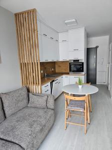 een woonkamer met een bank en een tafel bij Apartament - Osiedle Przylesie in Namysłów