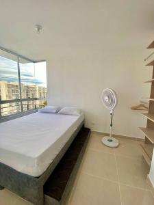 a bedroom with a bed with a fan and a window at Apartamento de descanso in Ricaurte