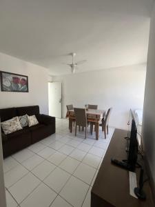 a living room with a couch and a table at Mar de Aruana - Apartamento Suíte com Ar Aracaju-SE in Aracaju