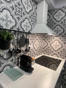 a kitchen with a sink and a wall with tiles at Cal Querol - Puigcerdà centre in Puigcerdà