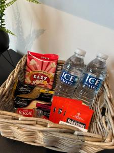 a basket with two bottles of water and snacks at 2 Bed 2 Bath in Digbeth in Birmingham