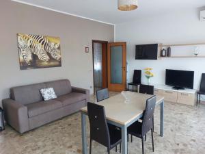 - un salon avec une table et un canapé dans l'établissement Casa Marinella, à San Giovanni Lupatoto