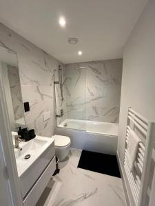 a white bathroom with a toilet and a sink at 2 Bed 2 Bath in Digbeth in Birmingham