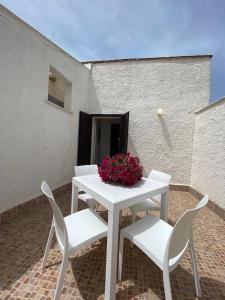 una mesa blanca con 2 sillas y un jarrón de flores en Sweet Life en Palermo