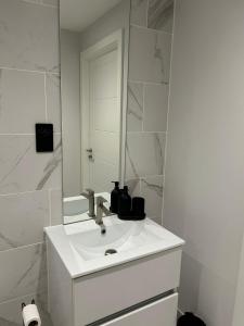 a white bathroom with a sink and a mirror at 2 Bed 2 Bath in Digbeth in Birmingham